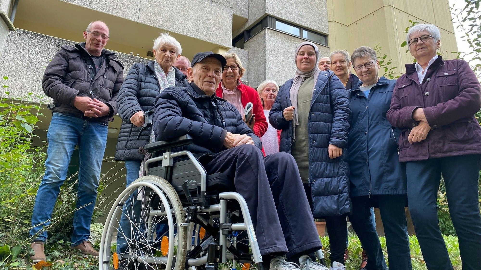 Menschen stehen vor einem Gebäude.