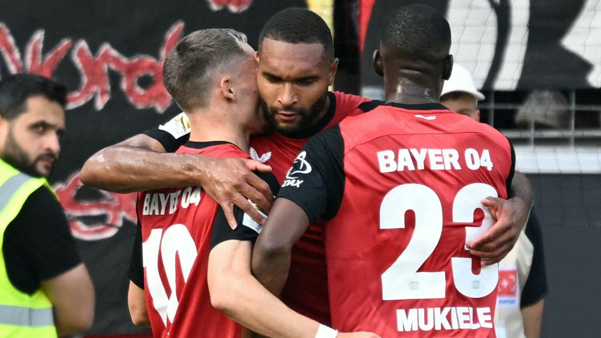 Bayer Leverkusens Jonathan Tah (M) mit Florian Wirtz (L) und Nordi Mukiele.