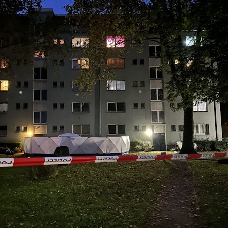 Vor dem Eingang eiens Hauses ist ein Sichtschutz der Polizei aufgebaut.