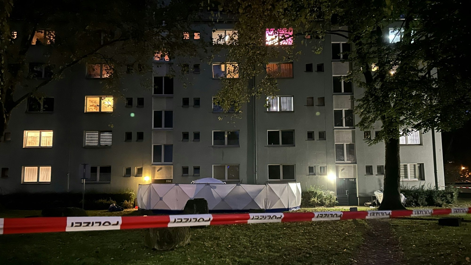 Vor dem Eingang eiens Hauses ist ein Sichtschutz der Polizei aufgebaut.