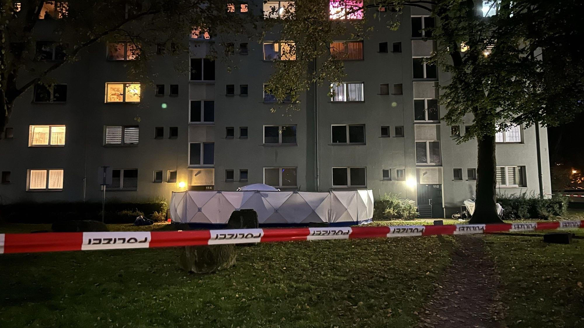 Flatterband und weißer Sichtschutz vor Mehrfamilienhaus, wo eine Frau getötet wurde
