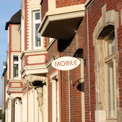 Zu sehen ist ein Gebäude aus Backstein mit den Schildern „Mobilé“ und „Stadthaus“.