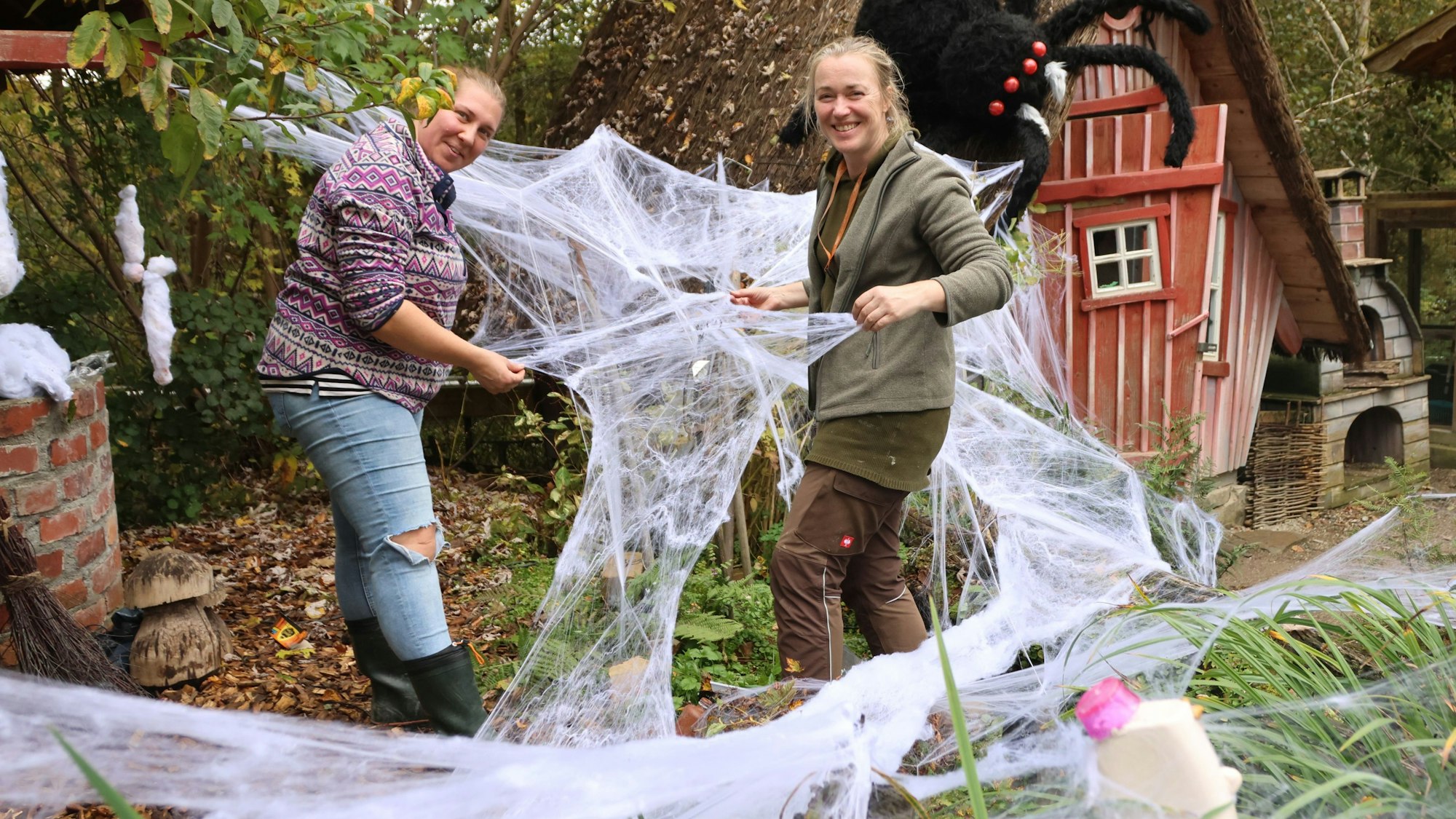 Die beiden Gärtnerinnen Caro (links) und Anne dekorieren im Affen- und Vogelpark in Reichshof-Eckenhagen den Hexengarten. Dort geht es jetzt schaurig schön, aber nicht unbedingt gruselig her. Unser Foto zeigt die Frauen bei der Arbeit, sie platzieren riesige Spinnennetze.