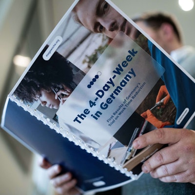 iAuf einer Mappe steht «The 4-Day-Week in Germany». Die Bilanz des Pilotprojekts zur Vier-Tage-Woche in Deutschland wurde bei der Landespressekonferenz in Düsseldorf vorgestellt.