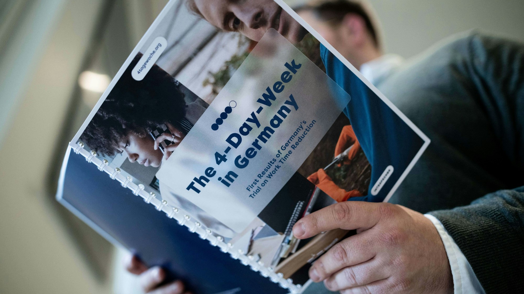 iAuf einer Mappe steht «The 4-Day-Week in Germany». Die Bilanz des Pilotprojekts zur Vier-Tage-Woche in Deutschland wurde bei der Landespressekonferenz in Düsseldorf vorgestellt.