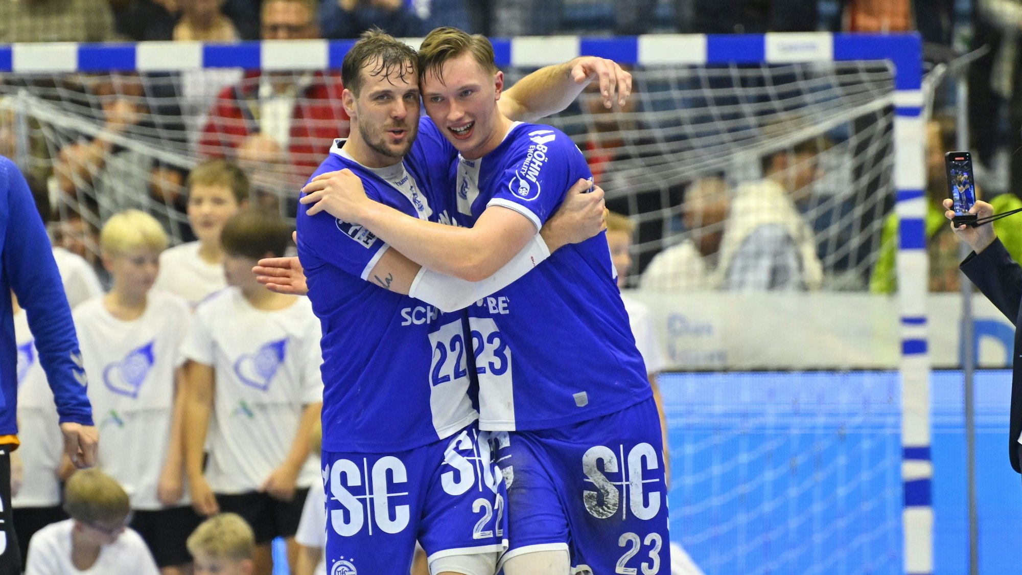 Kentin Mahe und Ole Pregler gehen umschlungen über Spielfeld.