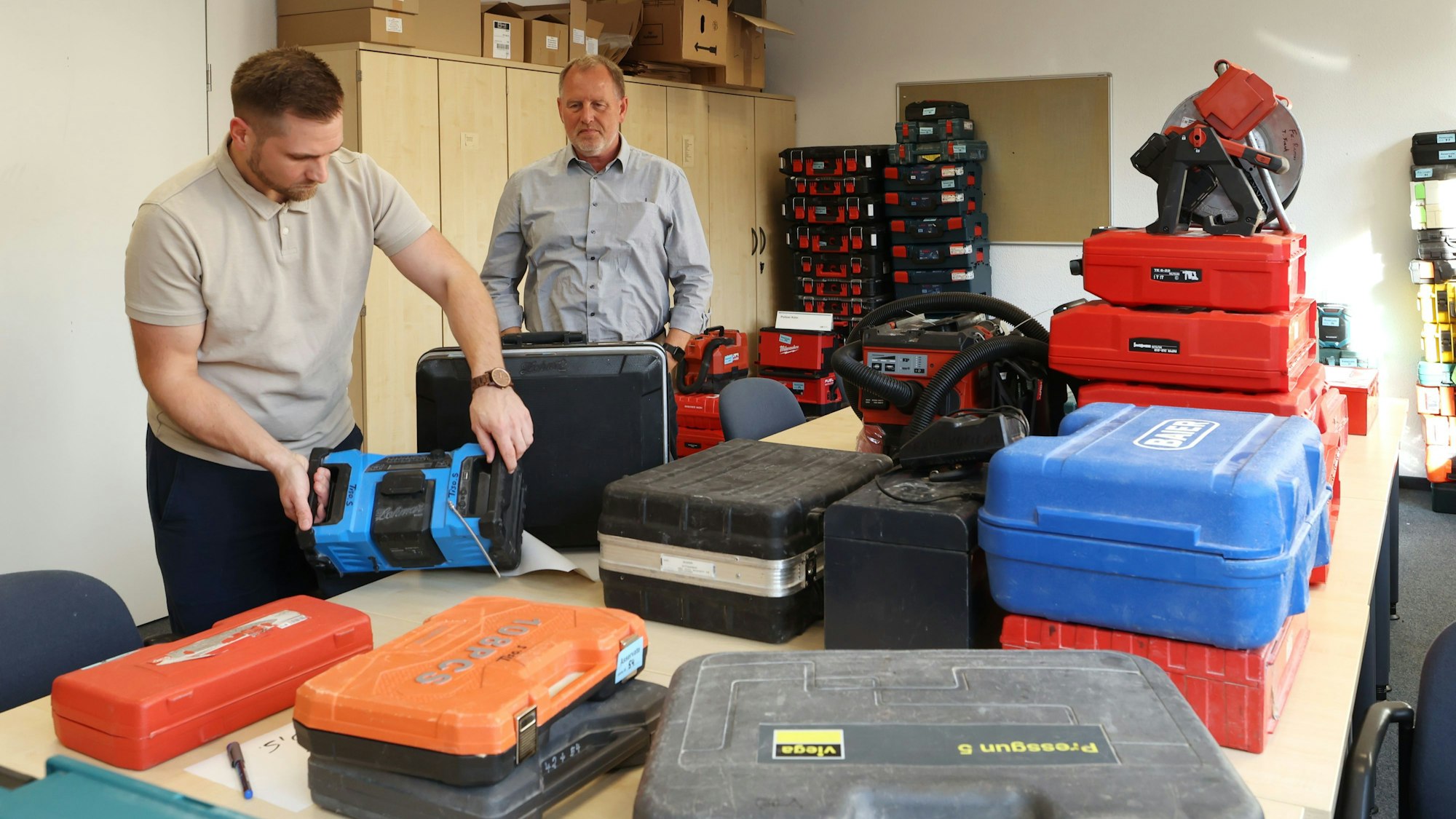 Die Polizei Köln präsentiert Werkzeuge und Maschinen, die aus den Fahrzeugen von Handwerkern gestohlen wurden. V.l.: Patrick Lohmar (Inhaber der Sanitärfirma Lohmar) und Ralf Dubendorff (Leiter des Kriminalkommissariats 74)