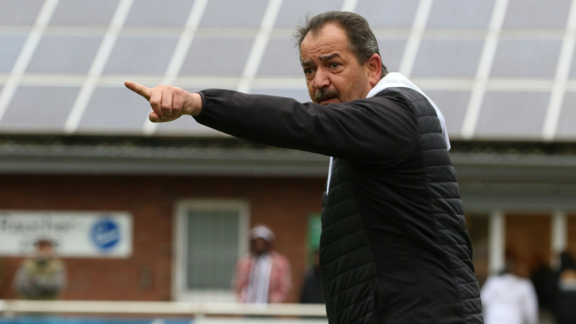 Das Bild zeigt den Coach des SV Nierfeld an der Seitenlinie, der seiner Mannschaft gestenreich eine Anweisung gibt.