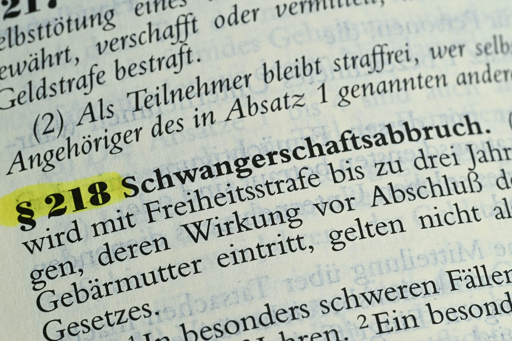 Das Bild zeigt einen Gesetzestext mit den Worten„ §218 Schwangerschaftsabbruch“. Der Paragraf ist farblich hervorgehoben.
