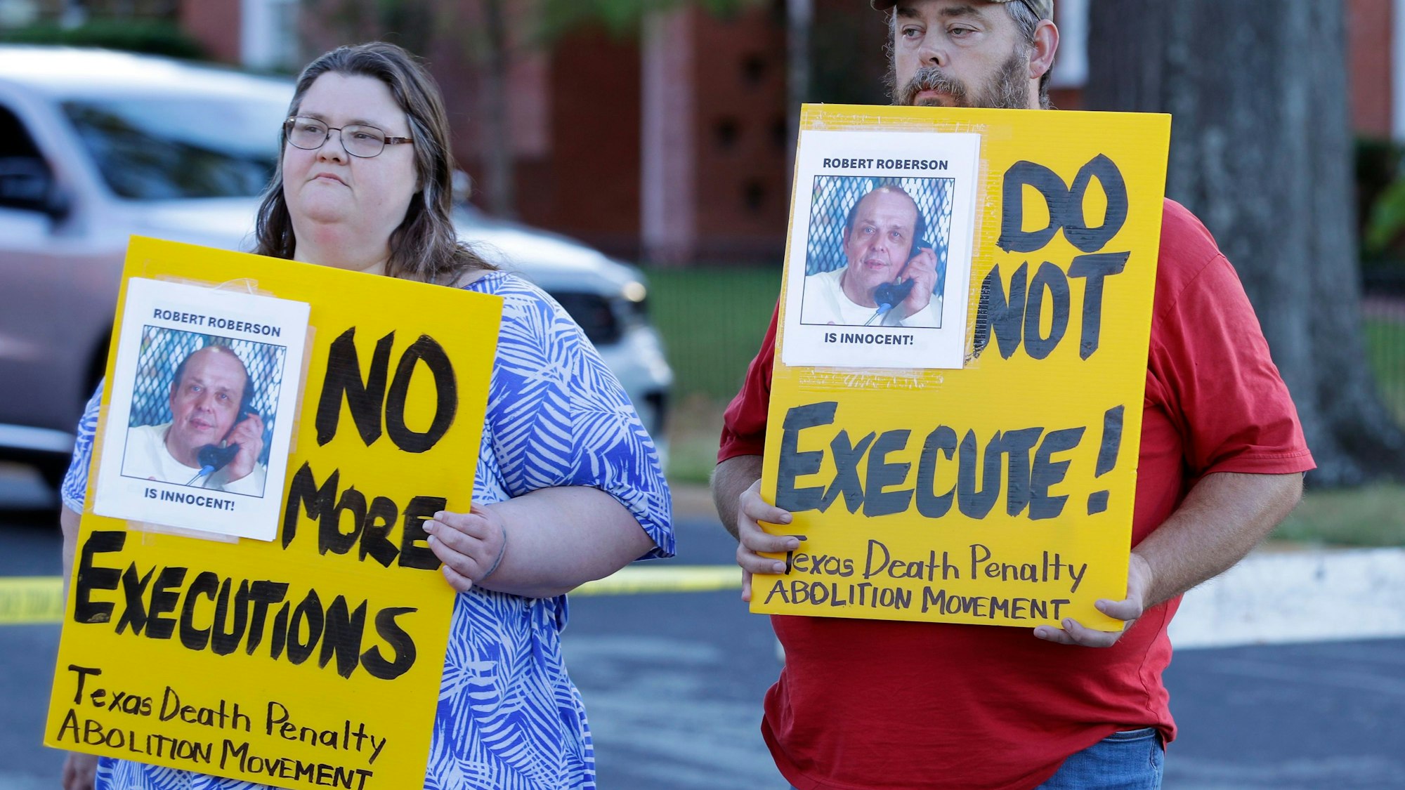 Jennifer Martin (links) und Thomas Roberson, älterer Bruder des verurteilten Häftlings Robert Roberson (rechts), protestieren mit Plakaten vor dem Gefängnis, in dem Roberson hingerichtet werden soll, in der Huntsville Unit des texanischen Staatsgefängnisses.