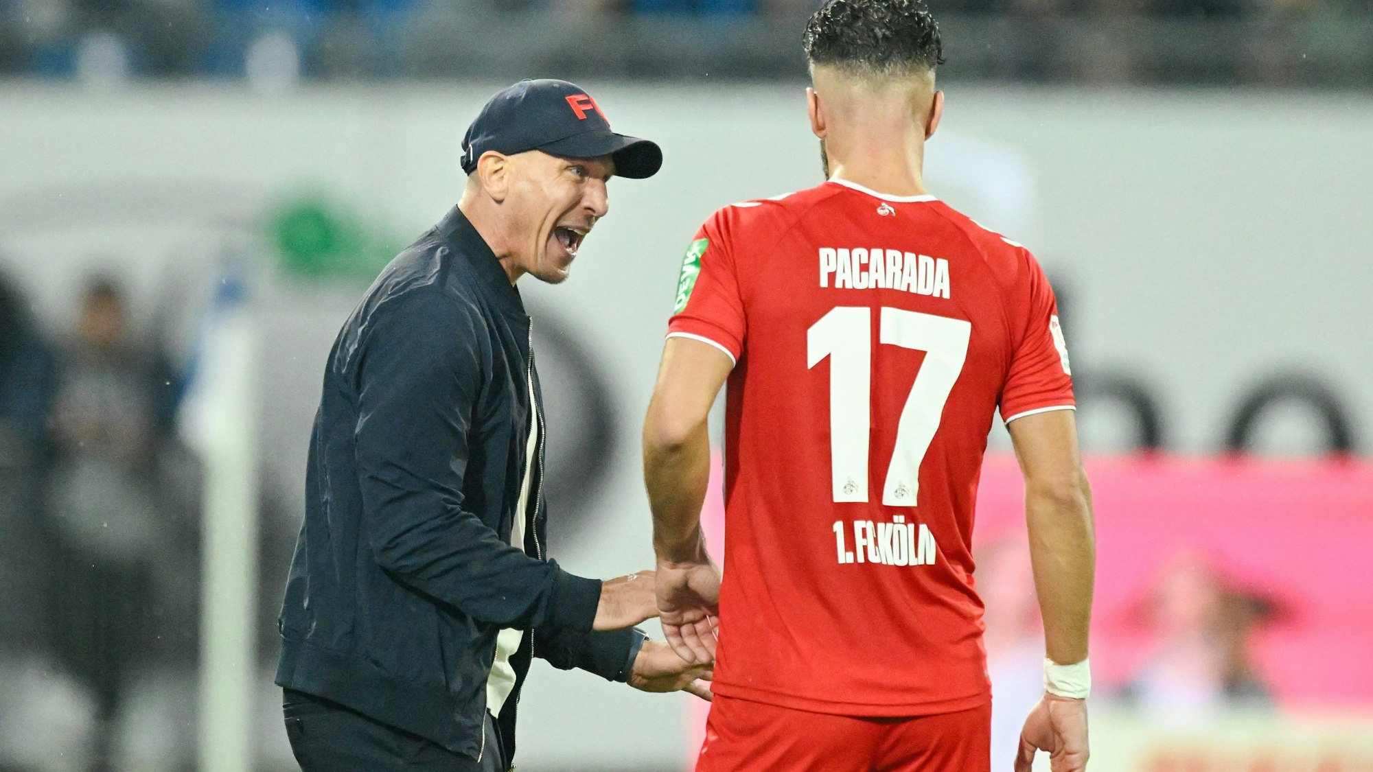 Kölns Trainer Gerhard Struber (l) spricht mit Kölns Leart Paqarada.