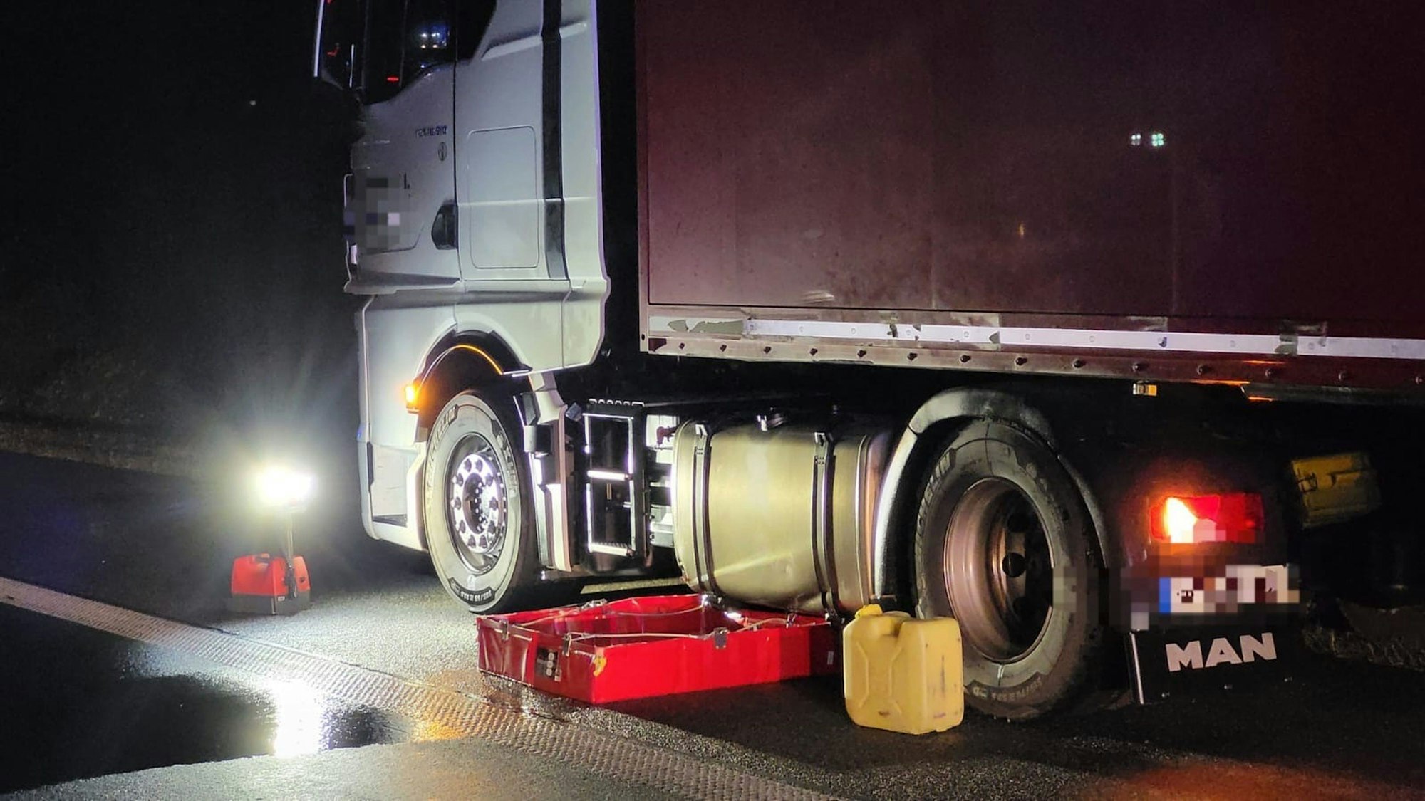 Eine Wanne steht unter dem Tank eines Transporters.