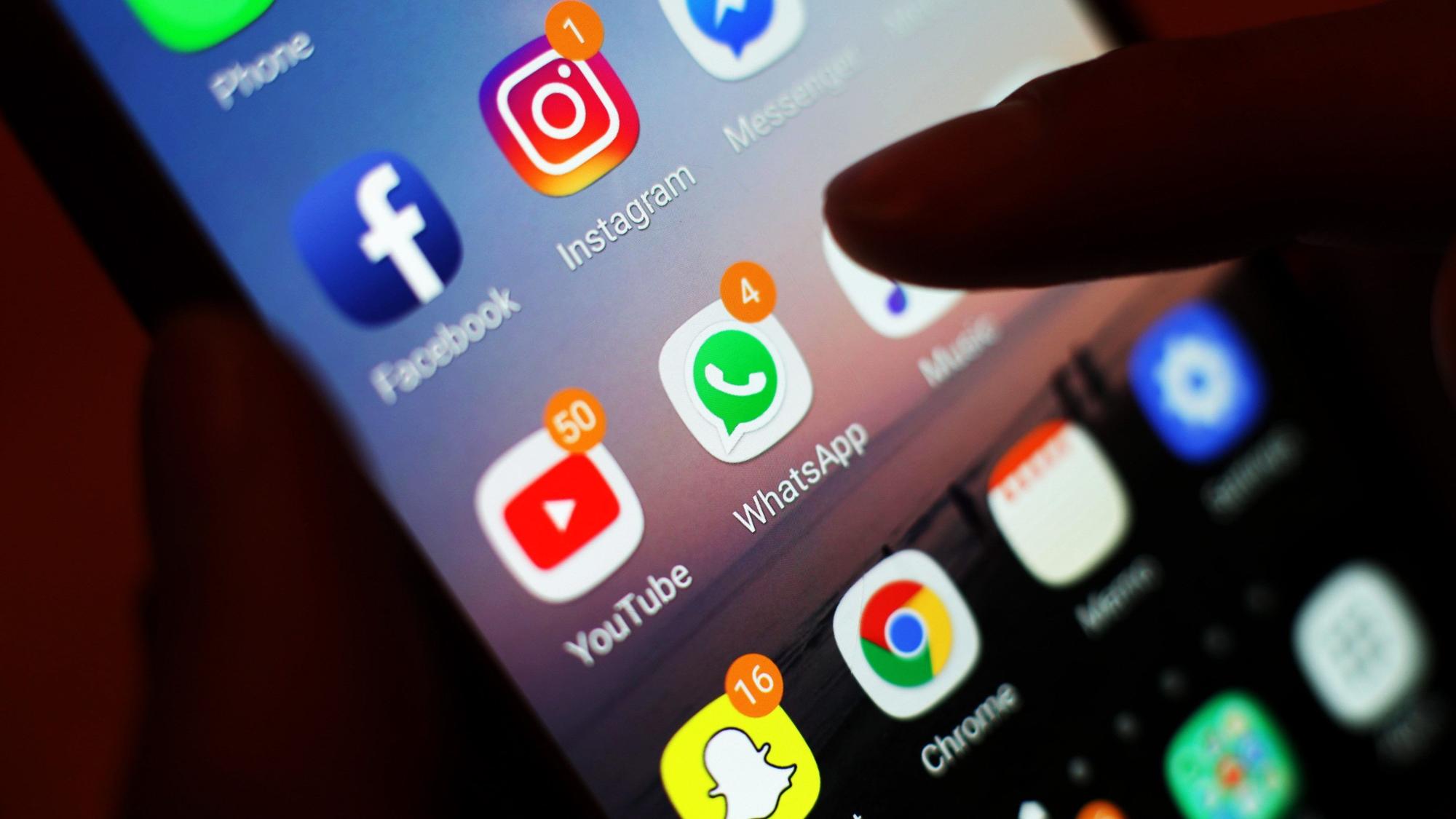Blick auf ein Handy mit den verschiedenen Social Media Apps, wie Facebook, Instagram, WhatsApp.