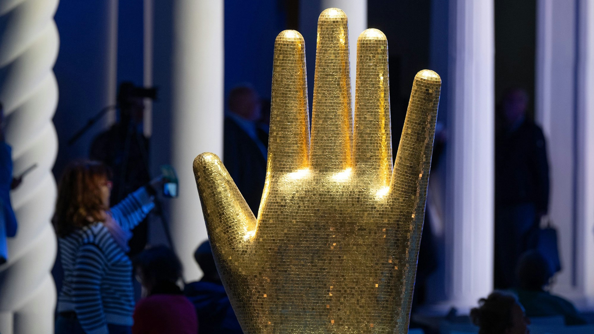 Eine überdimensionale goldene Hand wird im italienischen Pavillon angeleuchtet.