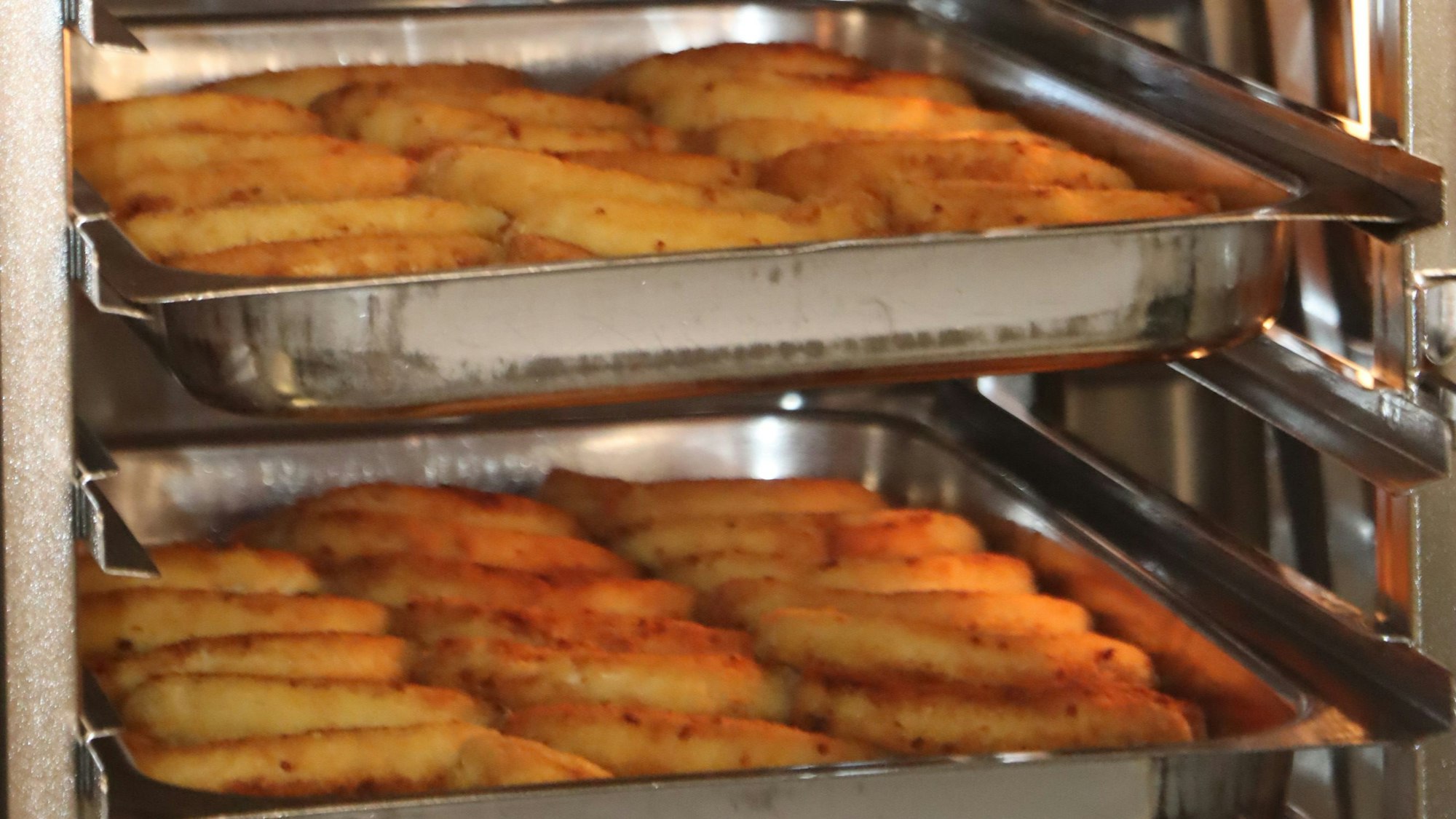 Zu sehen ist Essen auf Metalltabletts.