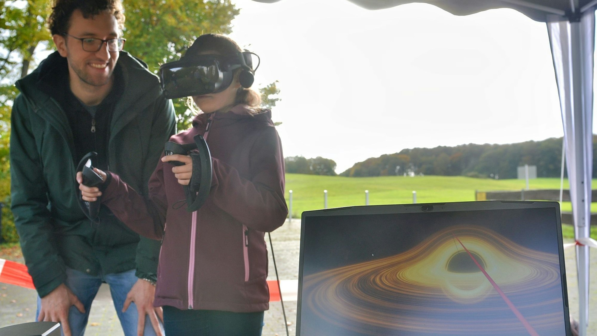 Marlon Bause steht neben einem Mädchen, das eine VR-Brille trägt.