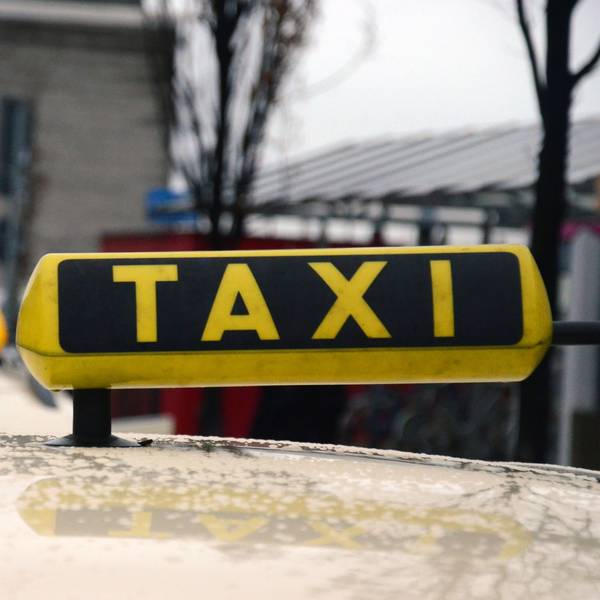 Das Bild zeigt ein Taxi-Schild auf einem Auto.