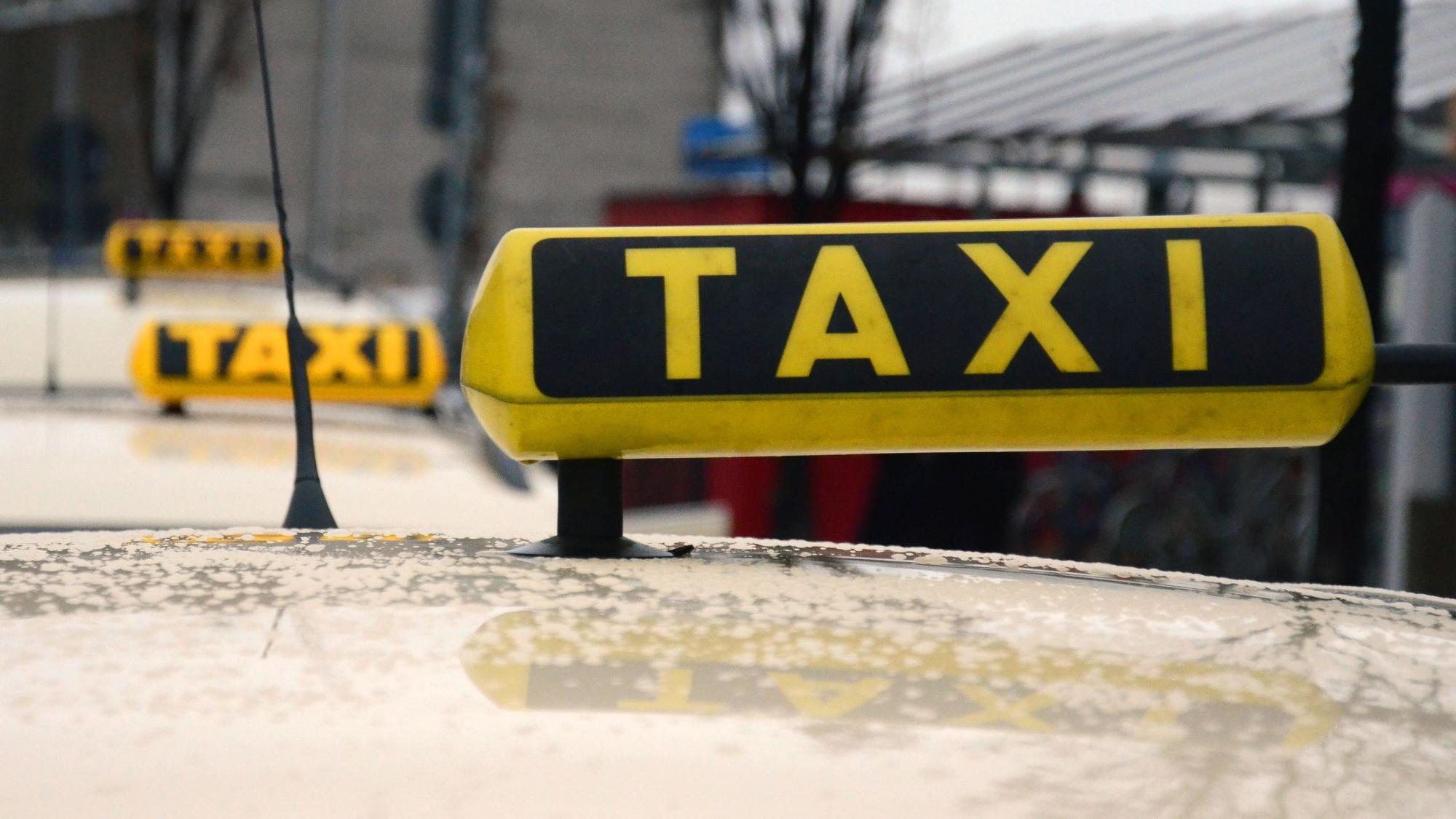 Das Bild zeigt ein Taxi-Schild auf einem Auto.