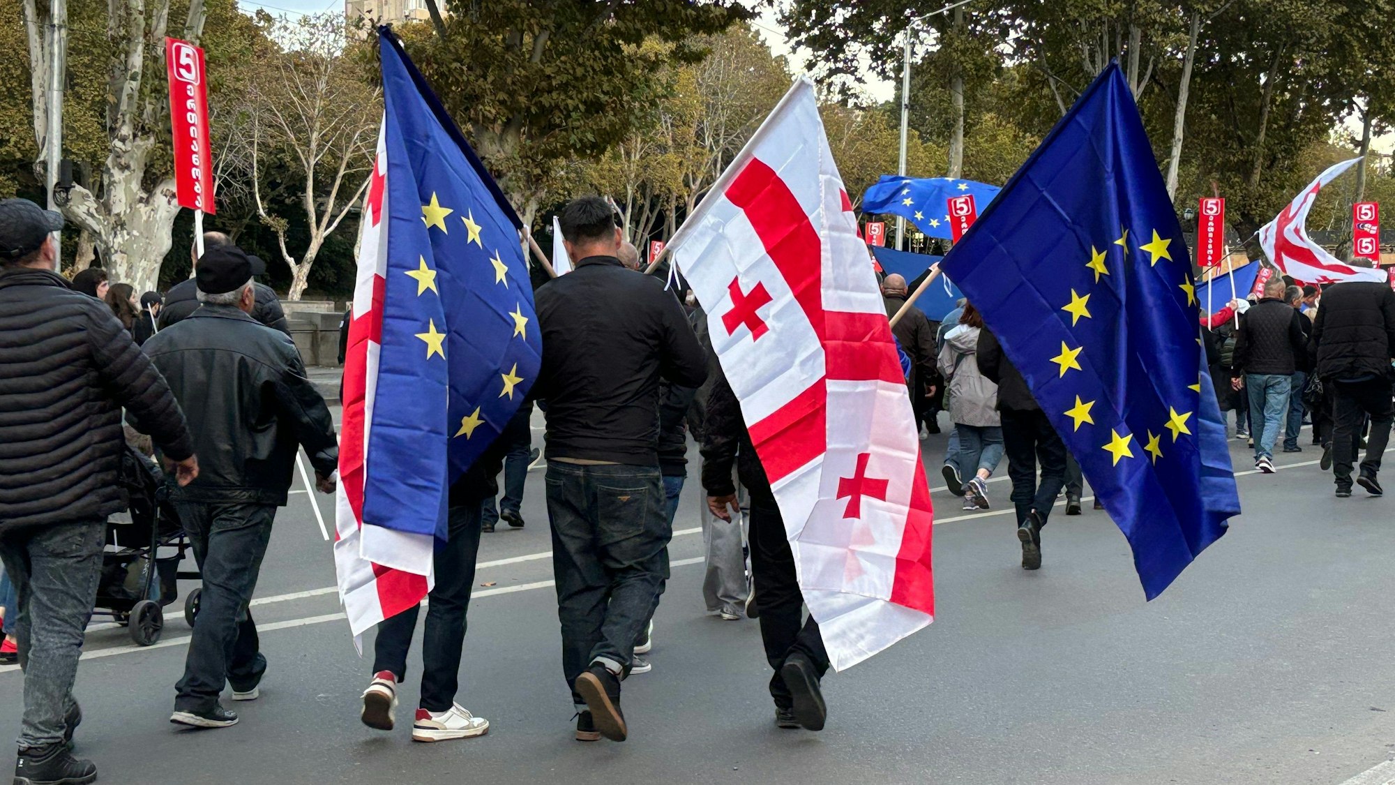 Menschen kommen mit georgischen und EU-Fahnen zu einer Demonstration in der georgischen Hauptstadt Tiflis.