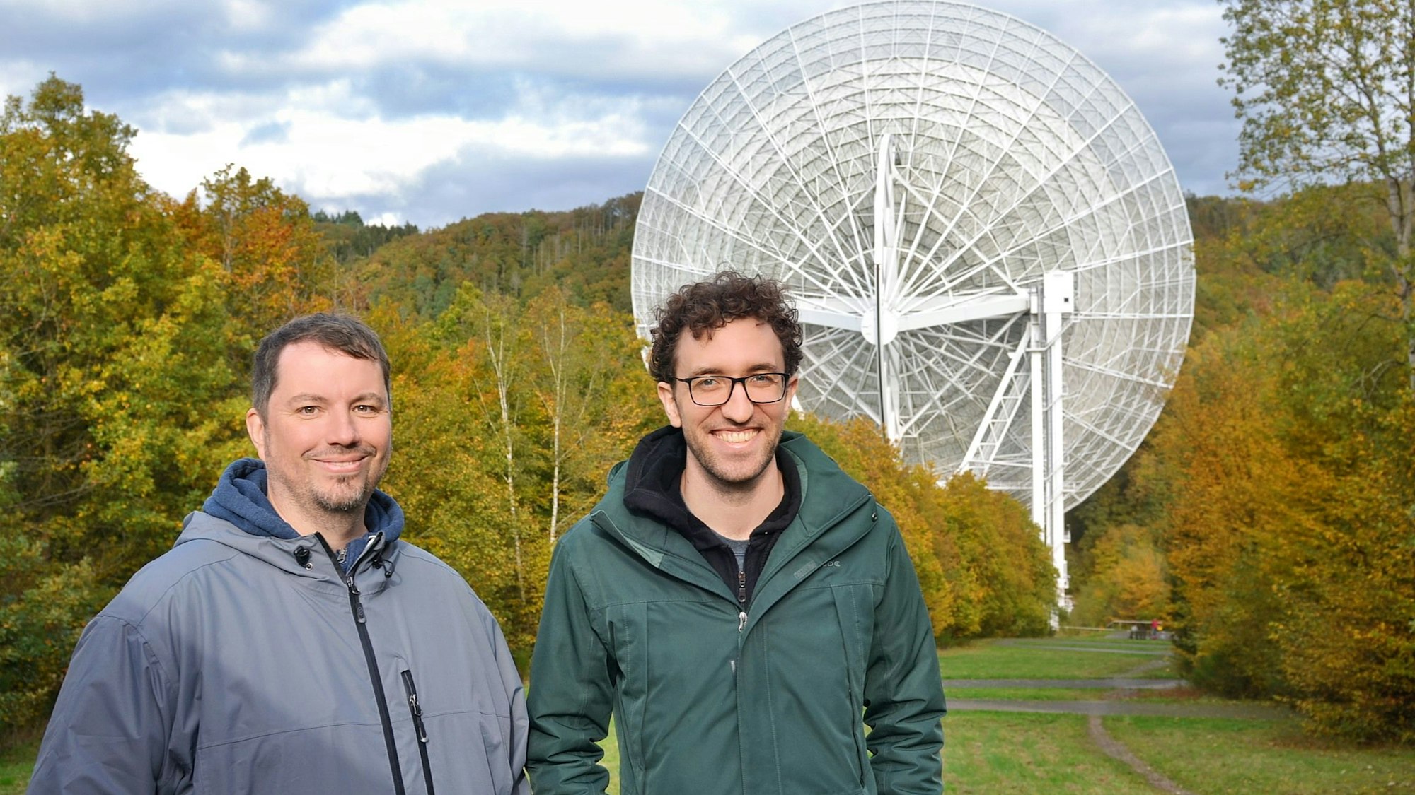 Die Forscher Benjamin Winkel und Marlon Bause (v.l.) stehen vor dem Radioteleskop in Effelsberg.