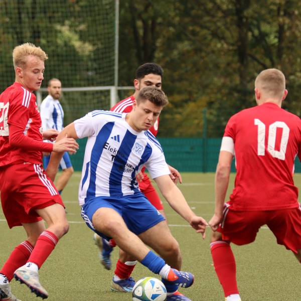 Ein ballführender Fußballer wird von gleich vier Gegenspielern umringt.