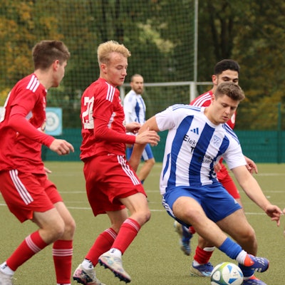 Ein ballführender Fußballer wird von gleich vier Gegenspielern umringt.