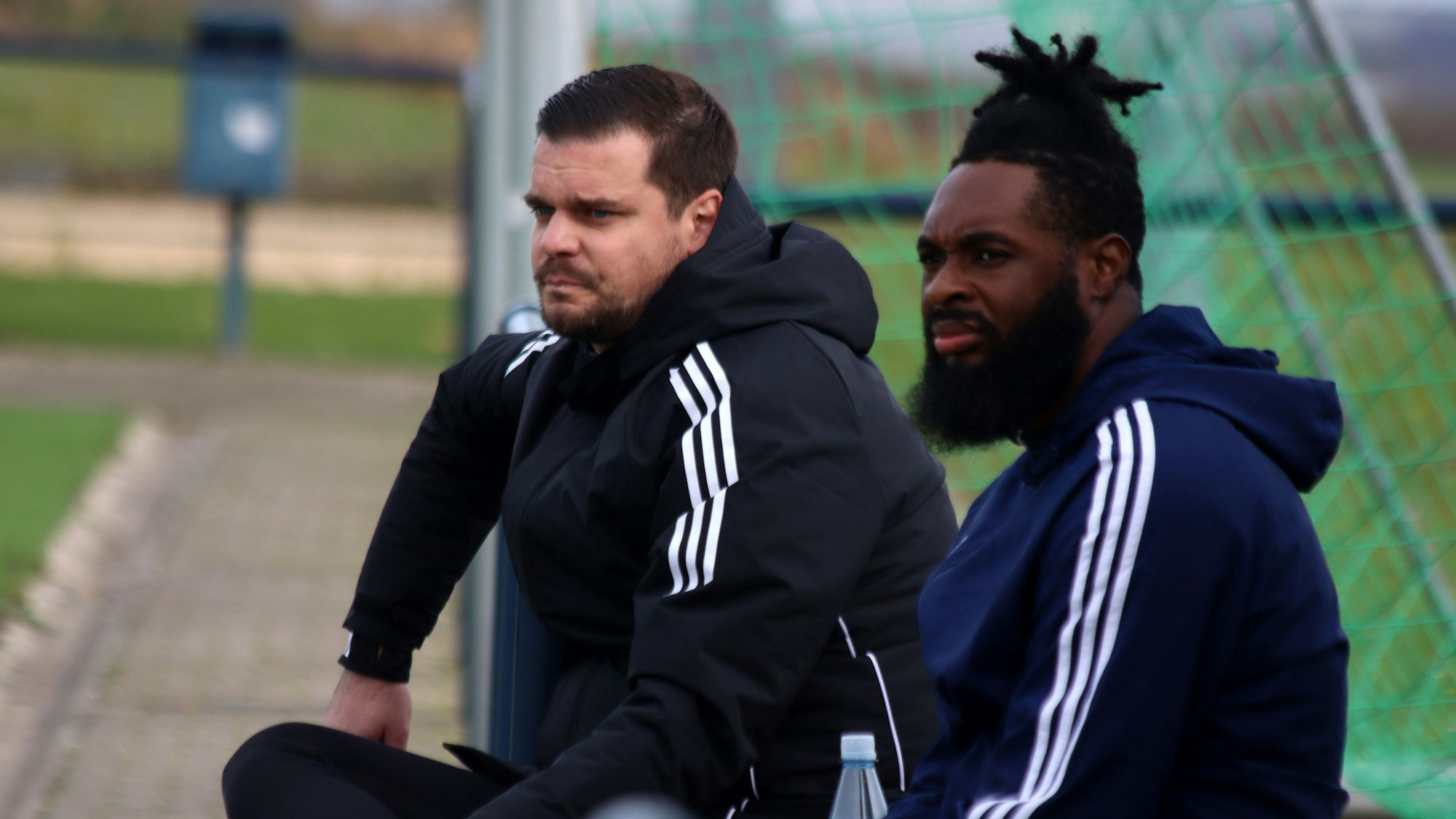 Der Trainer der Sportfreunde D-H-O sitzt neben einem Ersatzspieler.