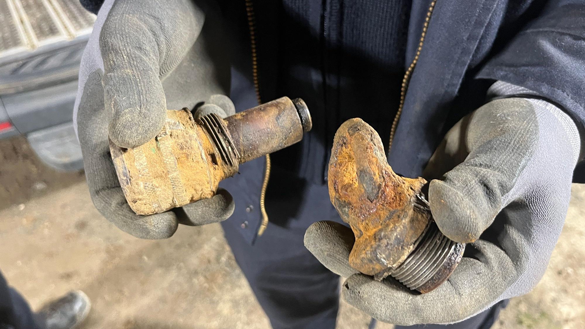 Zwei Hände zeigen den verbogenen Zünder und das Gewinde der Bombe in Troisdorf.