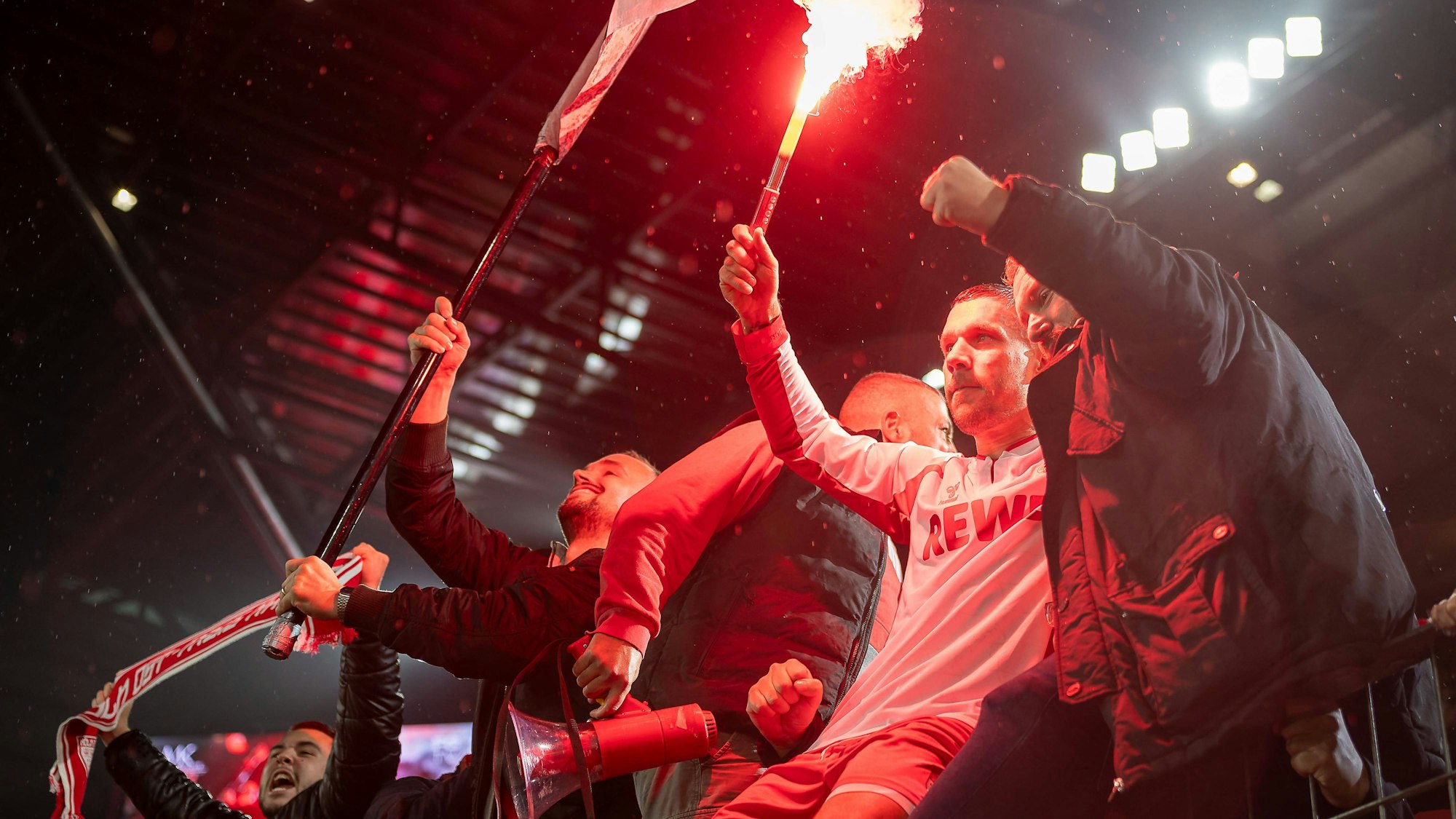 Lukas Podolski feiert mit einer Fackel in der Hand und seinen Fans.