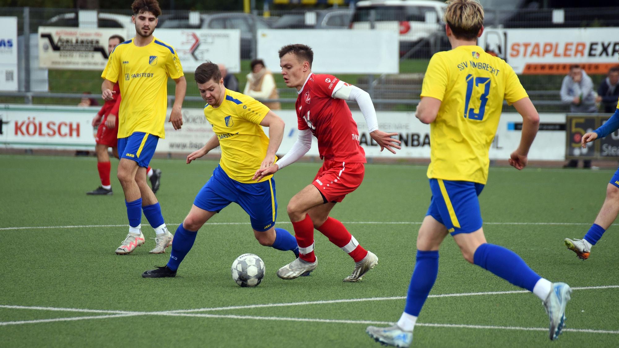 Eine Spielsituation zwischen zwei Mannschaften auf einem Fußballfeld.