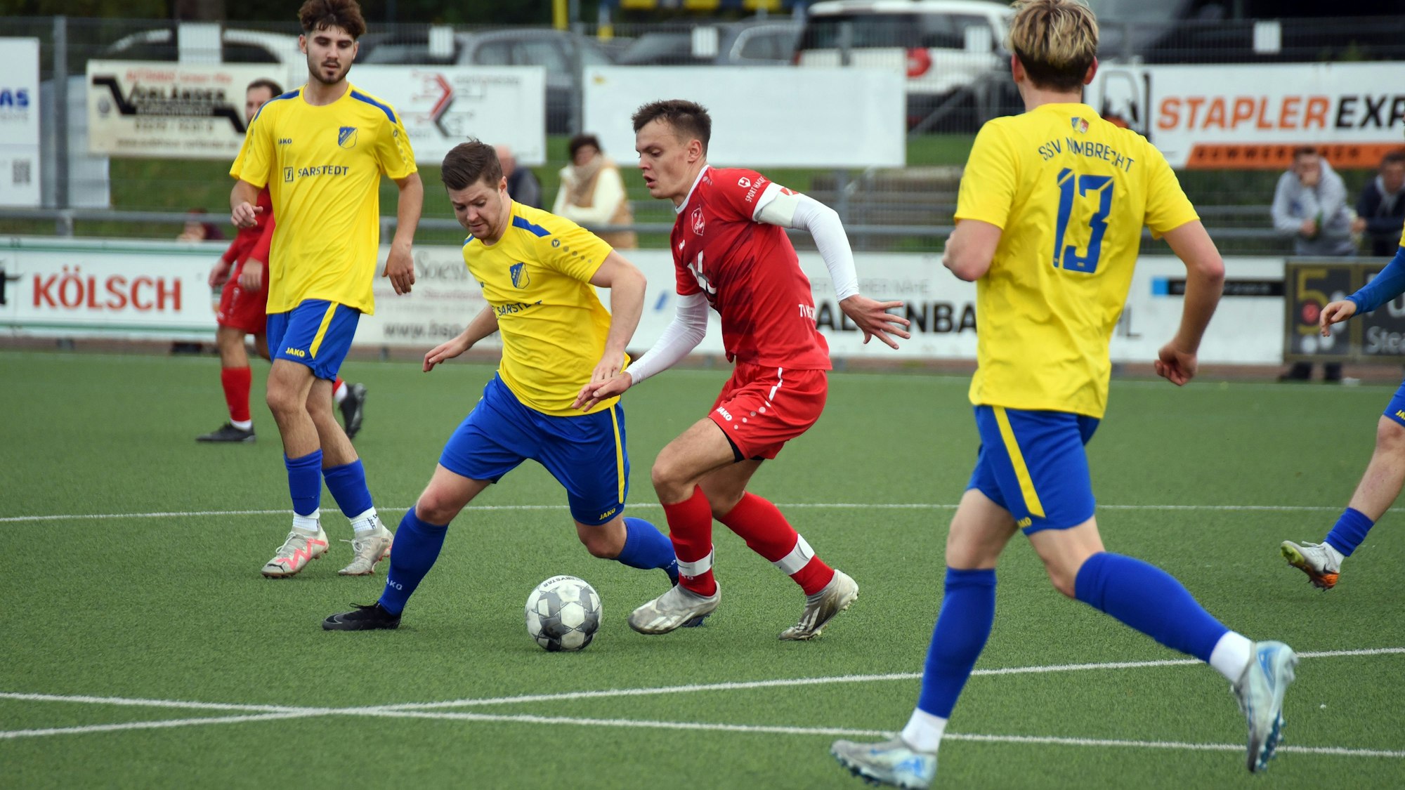 Eine Spielsituation zwischen zwei Mannschaften auf einem Fußballfeld.