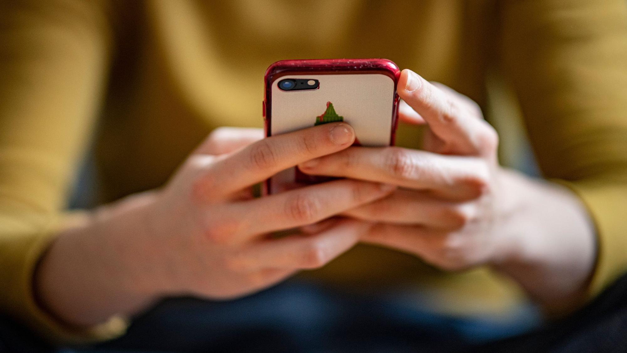 ARCHIV - 24.04.2021, Berlin: Eine junge Frau hält ein Smartphone in der Hand. (zu dpa "Deutsche verschicken wieder mehr SMS") Foto: Fabian Sommer/dpa +++ dpa-Bildfunk +++