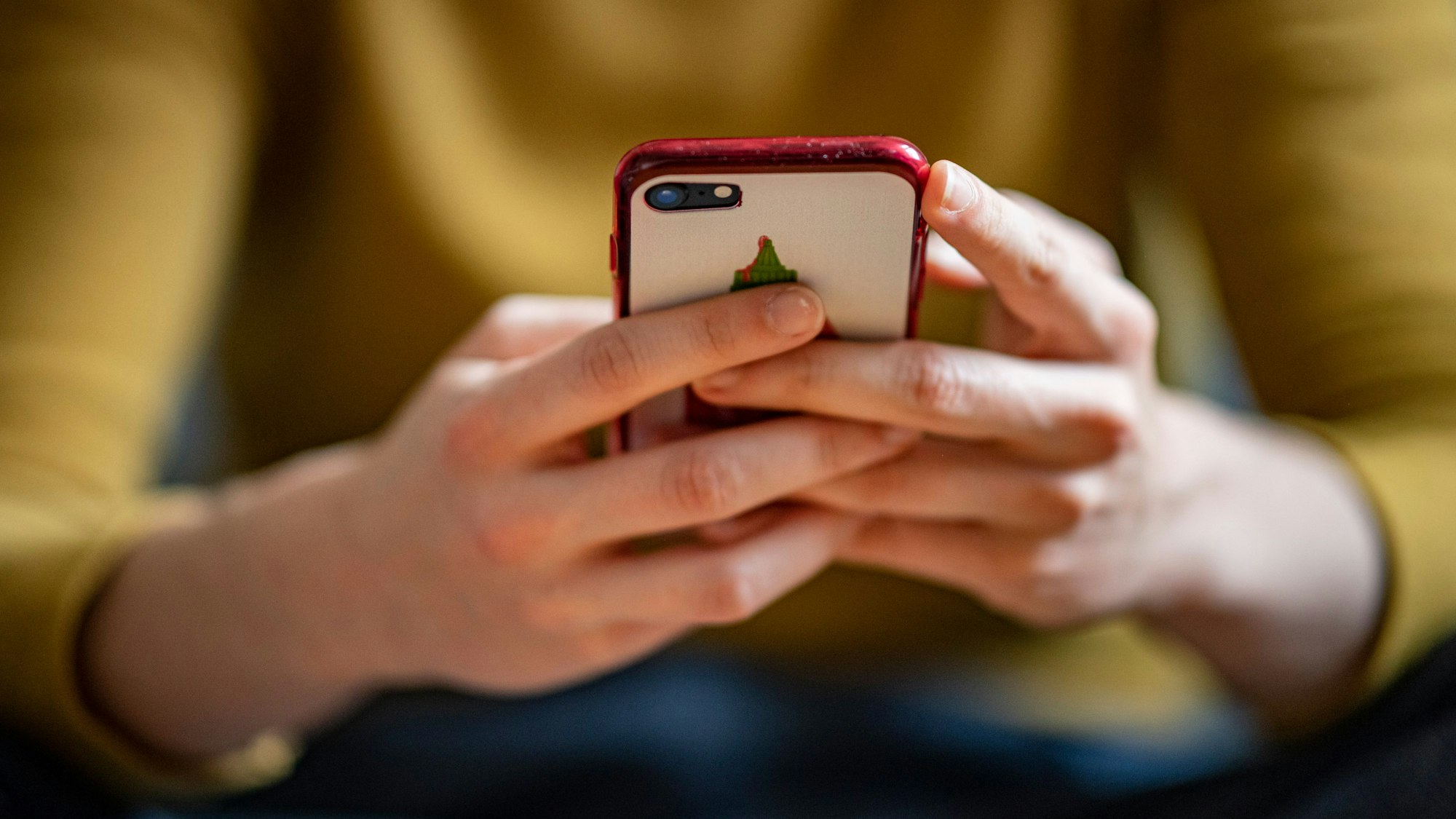 ARCHIV - 24.04.2021, Berlin: Eine junge Frau hält ein Smartphone in der Hand. (zu dpa "Deutsche verschicken wieder mehr SMS") Foto: Fabian Sommer/dpa +++ dpa-Bildfunk +++