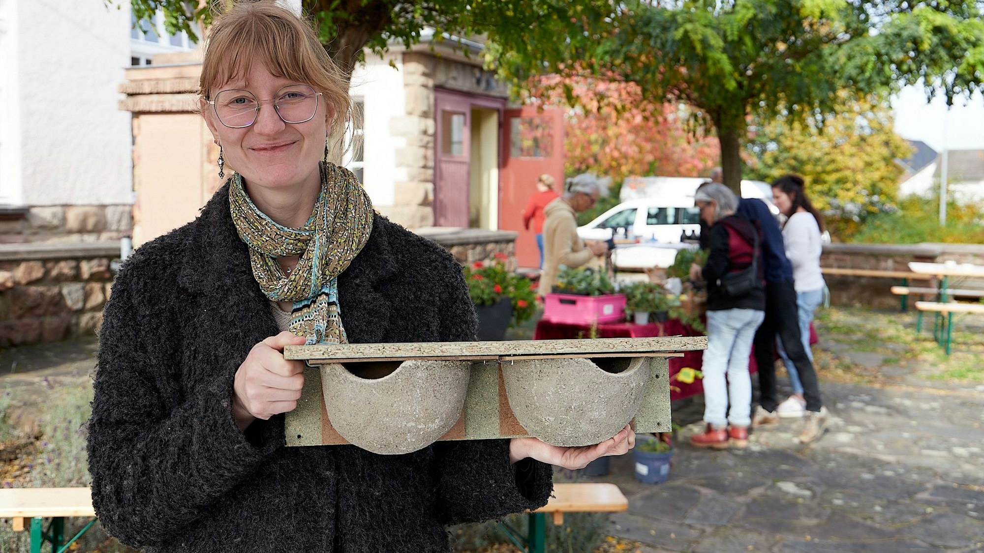 Sarah Hartmann zeigt Nisthilfen für Mehlschwalben.