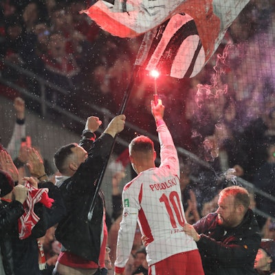 Lukas Podolski mit Pyrofackel in der Hand nach seinem Abschiedsspiel in Köln am 10. Oktober 2024.