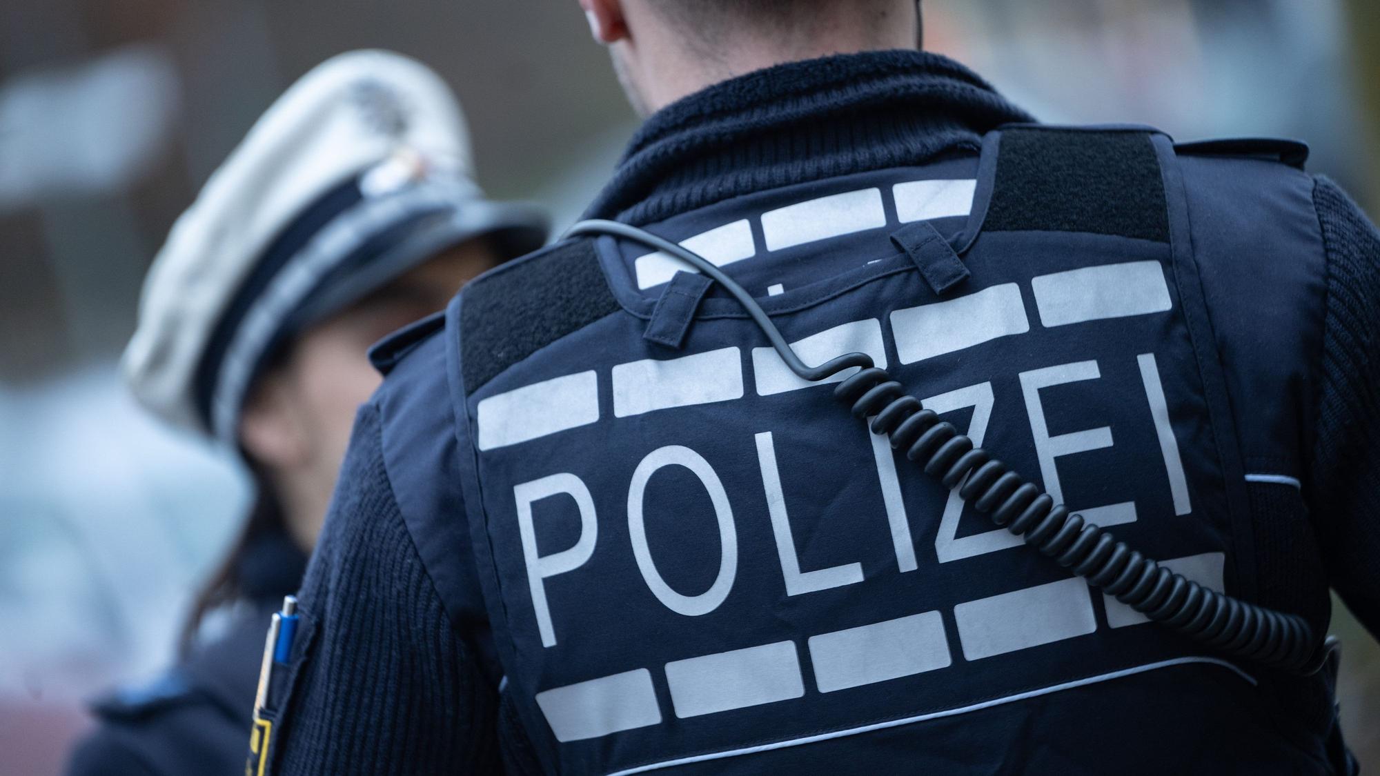 Eine Polizistin (l) und ein Polizist gehen im Rahmen eines Fototermins eine Straße entlang (gestellte Szene).