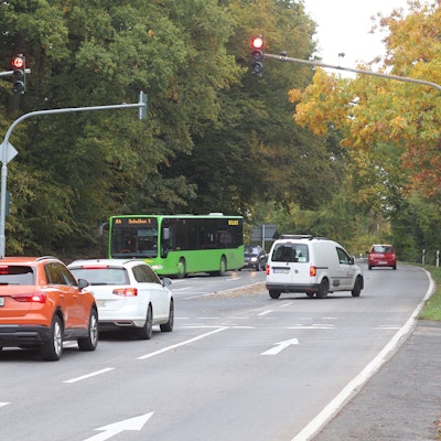 Straße mit Autoverkehr und Hinweisschild