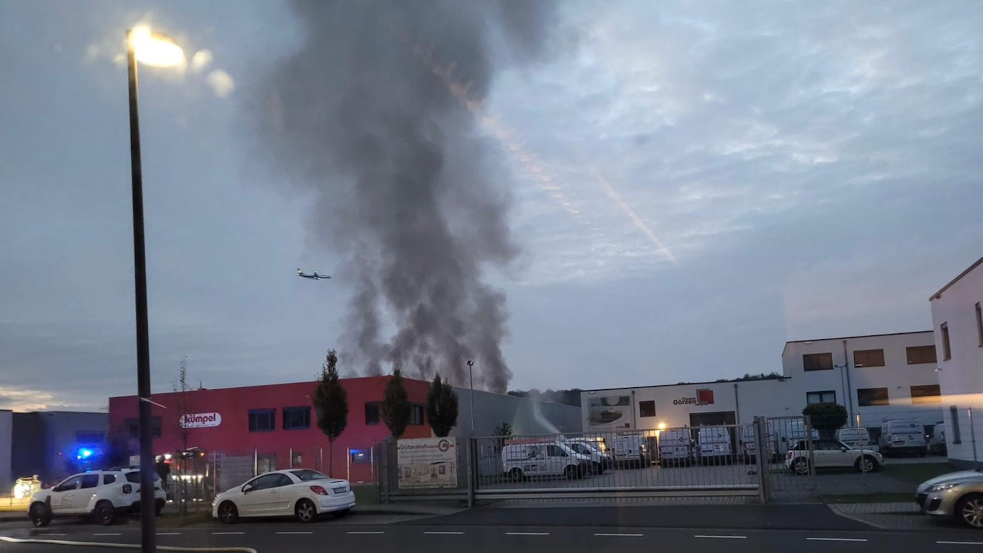 Eine Rauchsäule steigt über einem Dach auf.
