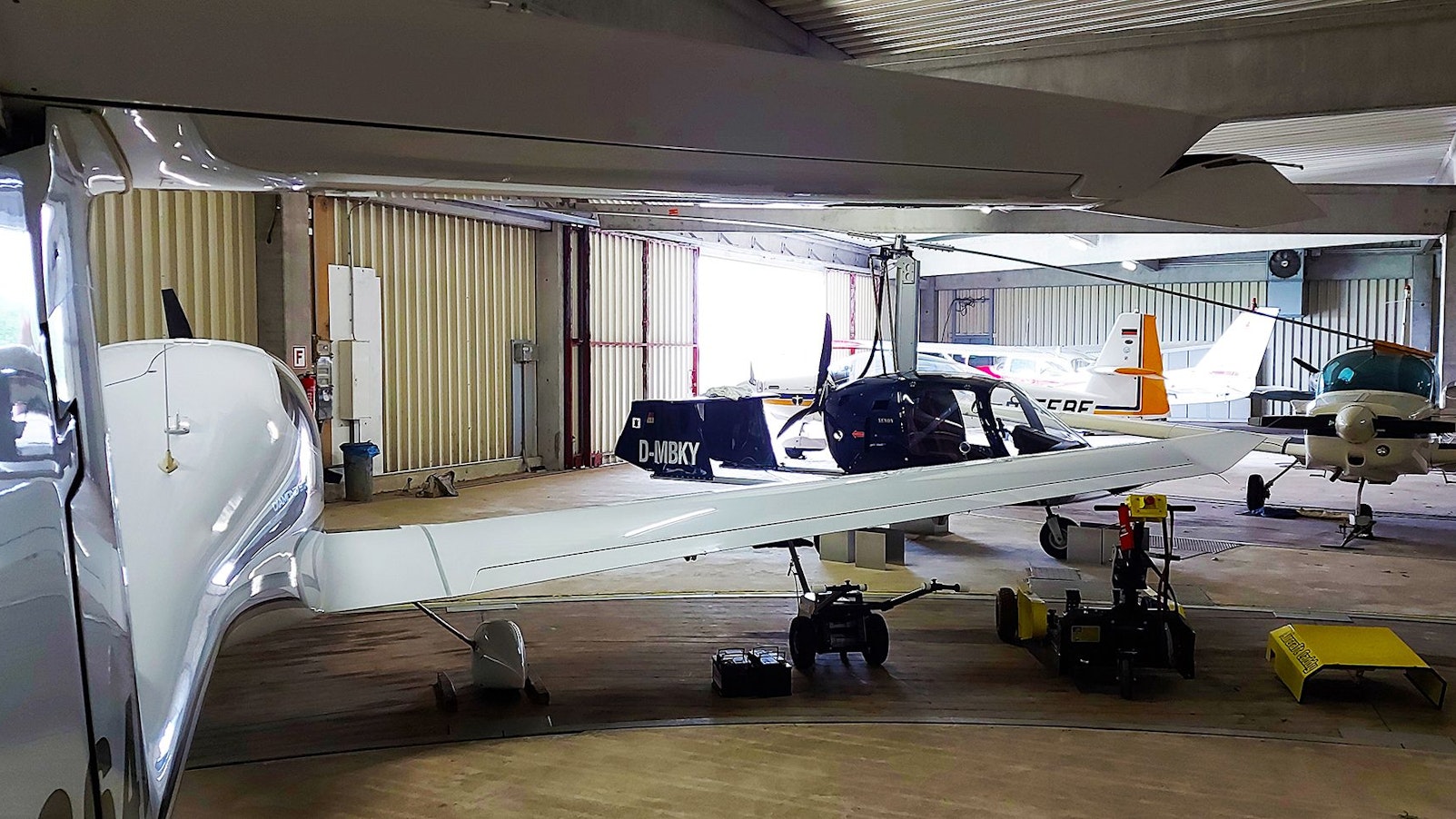 In einem Hangar stehen mehrere kleine Flugzeuge.