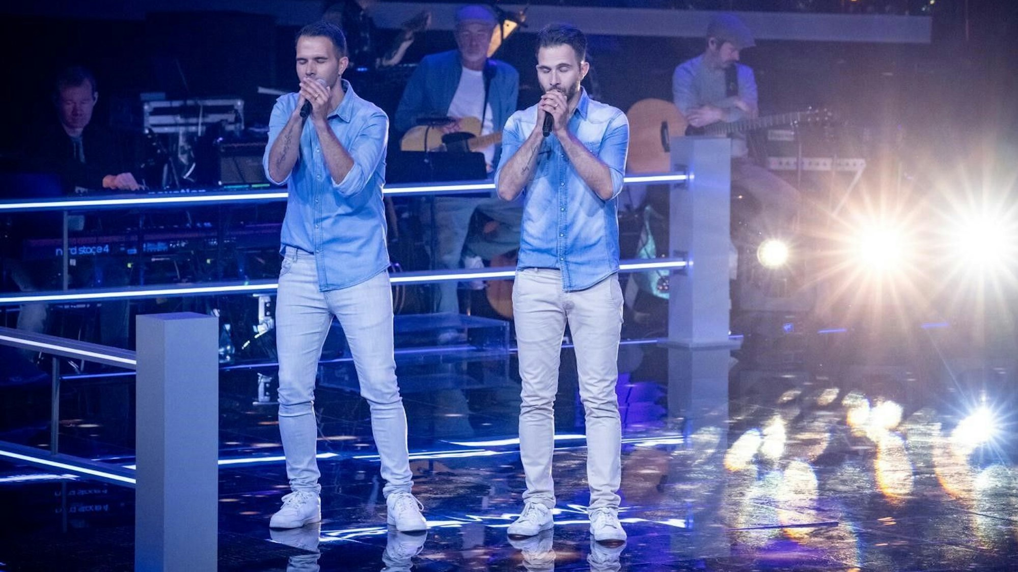 Zwei Männer singen auf einer Bühne.