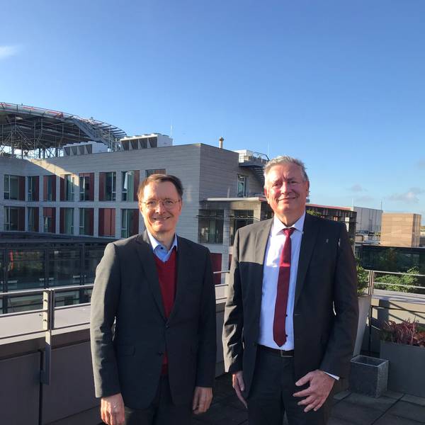 Zu sehen sind Karl Lauterbach (links) und Edgar Schömig vor dem Kölner Universitätsklinikum.