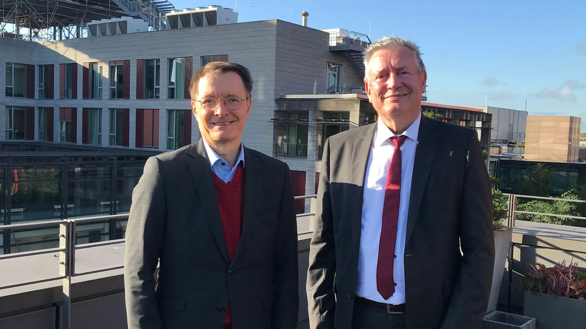 Zu sehen sind Karl Lauterbach (links) und Edgar Schömig vor dem Kölner Universitätsklinikum.