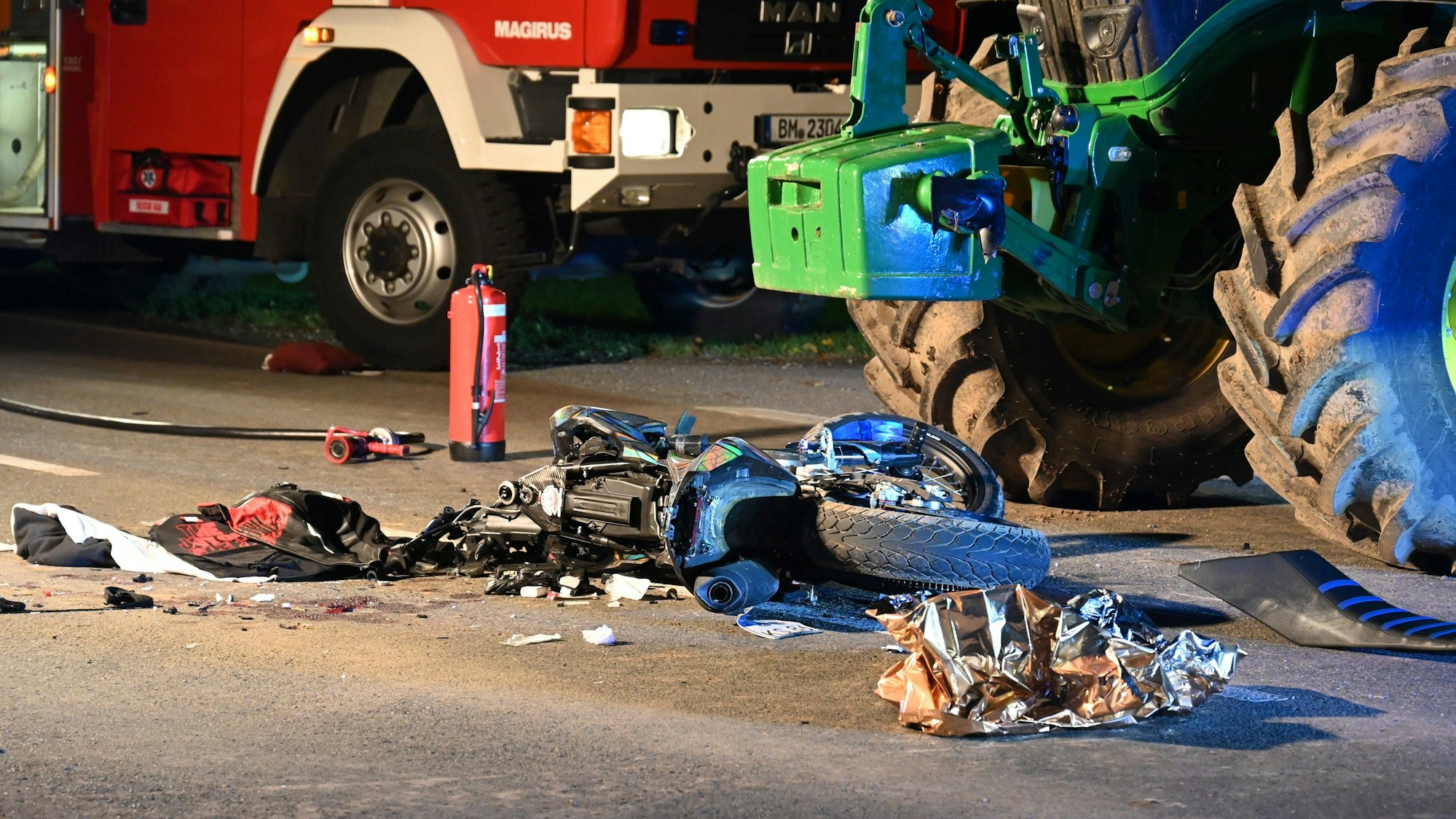 Ein zerstörtes Motorrad neben einem Traktor