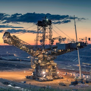 Auf dem Bild ist ein Kohlebagger bei Sonnenuntergang zu sehen.