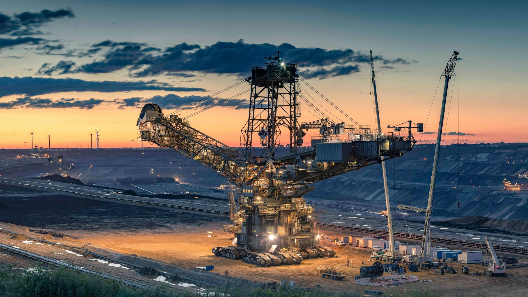 Auf dem Bild ist ein Kohlebagger bei Sonnenuntergang zu sehen.