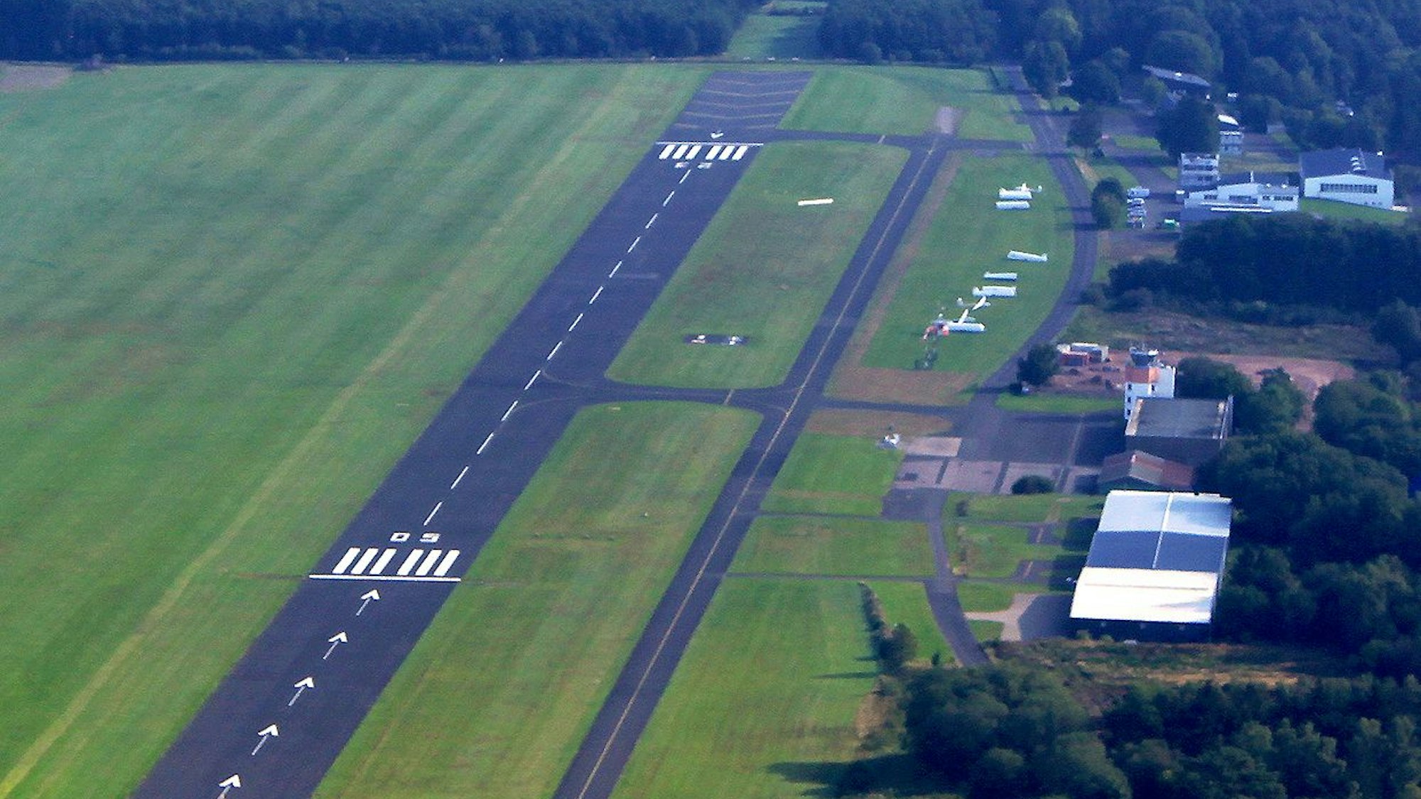 Rechts und links von der Landebahn des Flugplatzes Dahlemer Binz sind grüne Wiesen.
