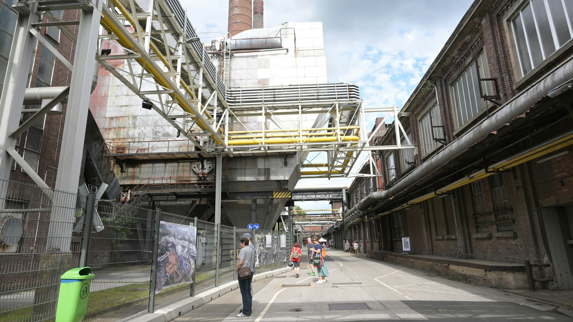 Blick in eine Straße, an der rechts und links Industriehallen stehen.