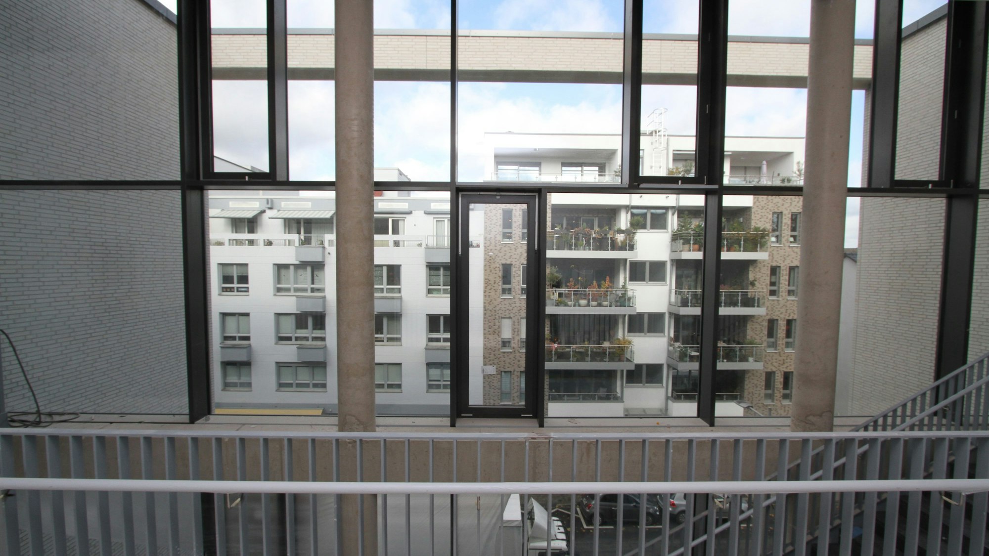 Häuser durch eine untergliederte Fensterfront gesehen.