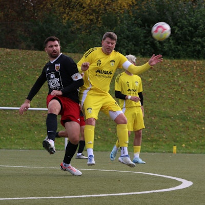 Ein Spieler hat den Ball weggeschossen, ein Gegenspieler bedrängt ihn.