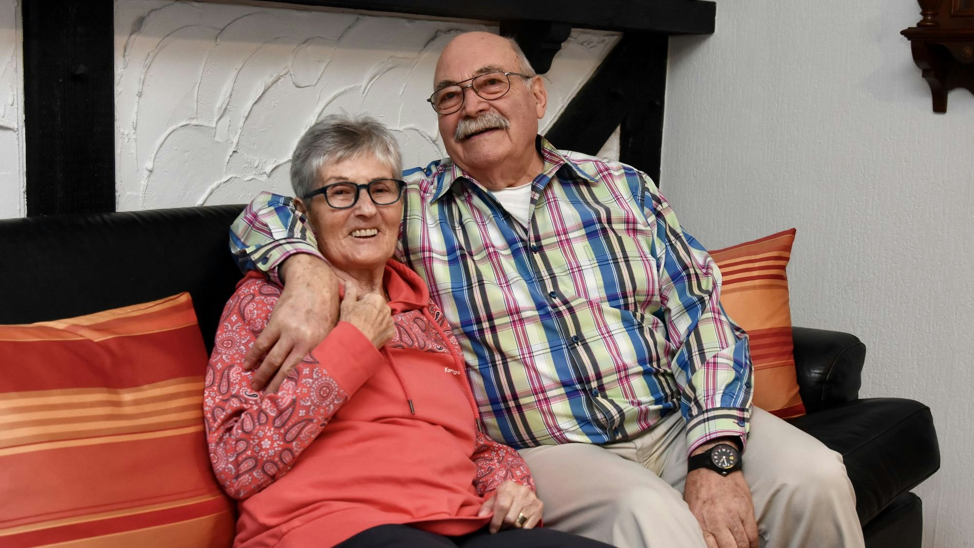 Ein Mann und eine Frau sitzen auf einem Sofa.